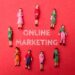 Miniature businesswomen with the word ONLINE MARKETING