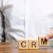 Wooden blocks with the word CRM (Customer Relationship Management) and businessman